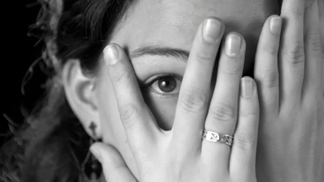 An anxious woman hiding behind her hands