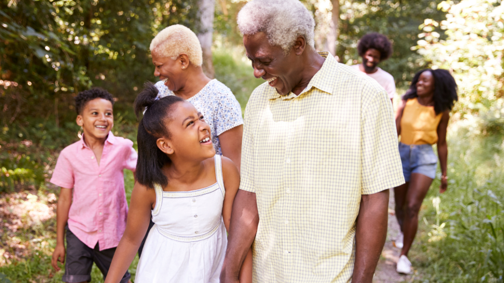 BIPOC grandfather and granddaughter smiling
