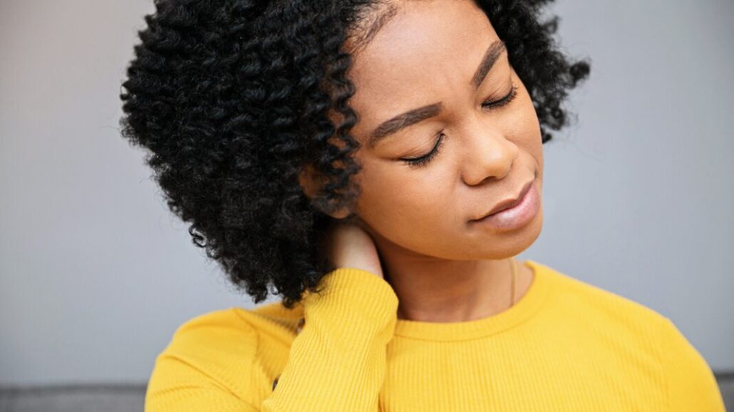 black woman holding neck due to muscle tension