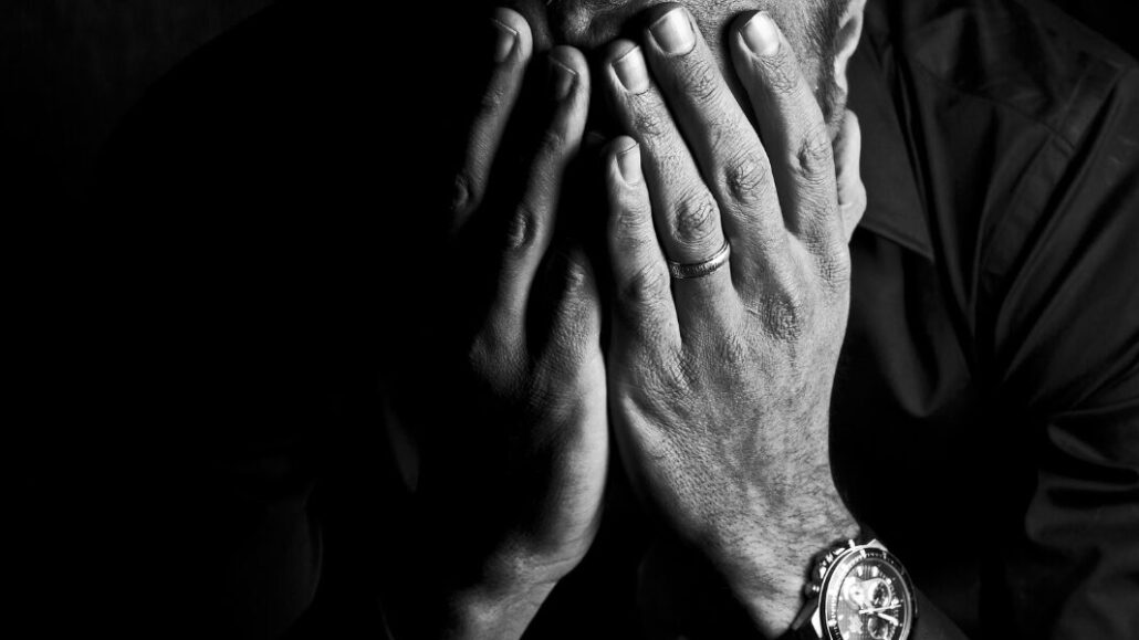 grieving man with head in hands