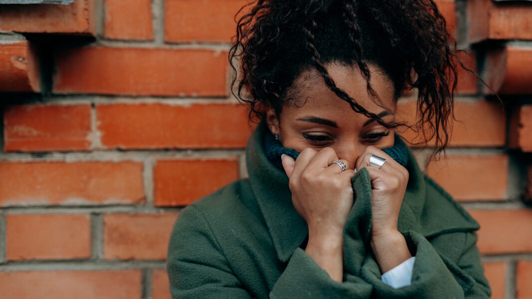 woman grieving with head in sweatshirt