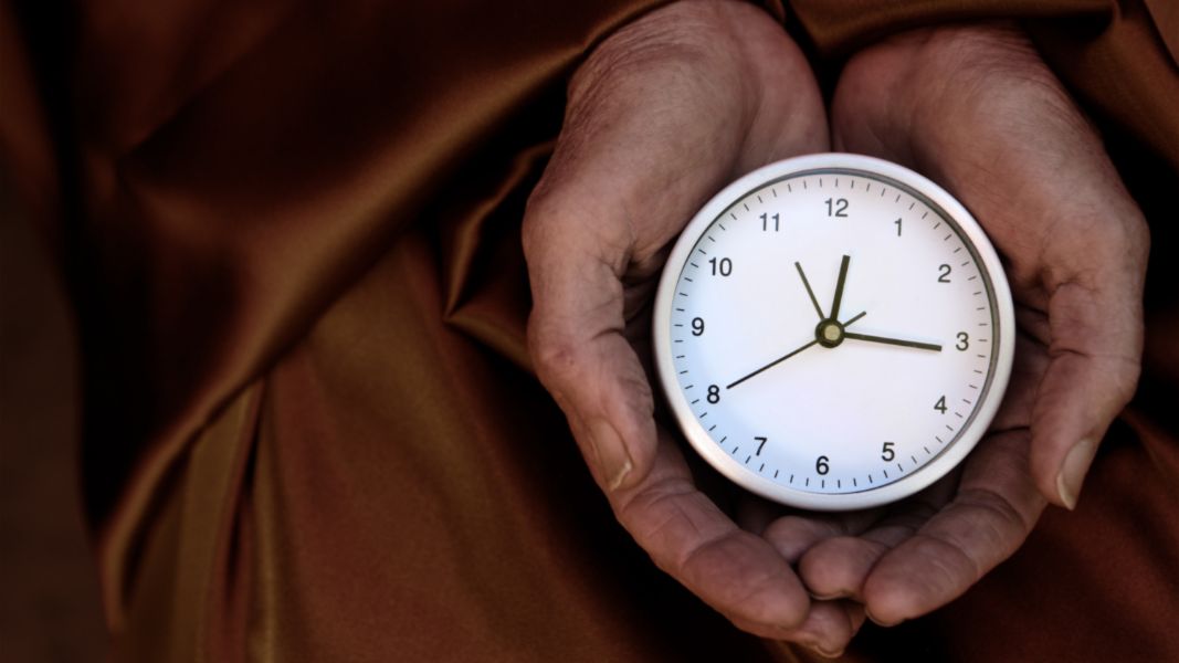 person aging well holding a clock
